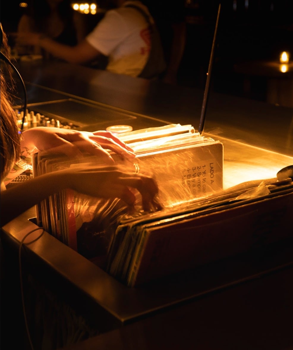 Vinilos y tornamesa bajo luz cálida en el bar 55DB