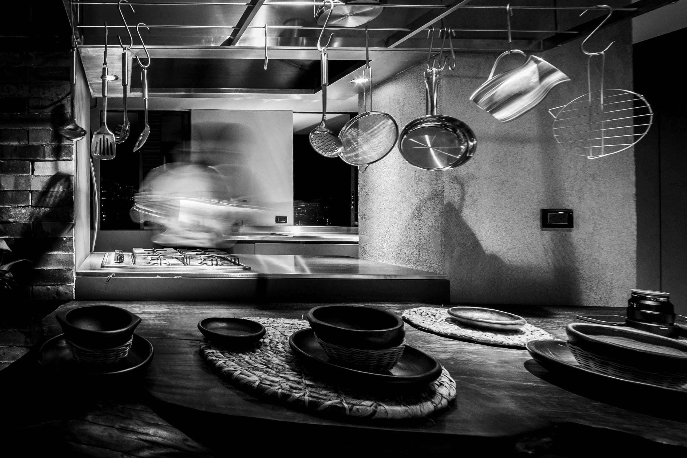 Cocina abierta con utensilios colgantes, fotografía en blanco y negro, La Almenara