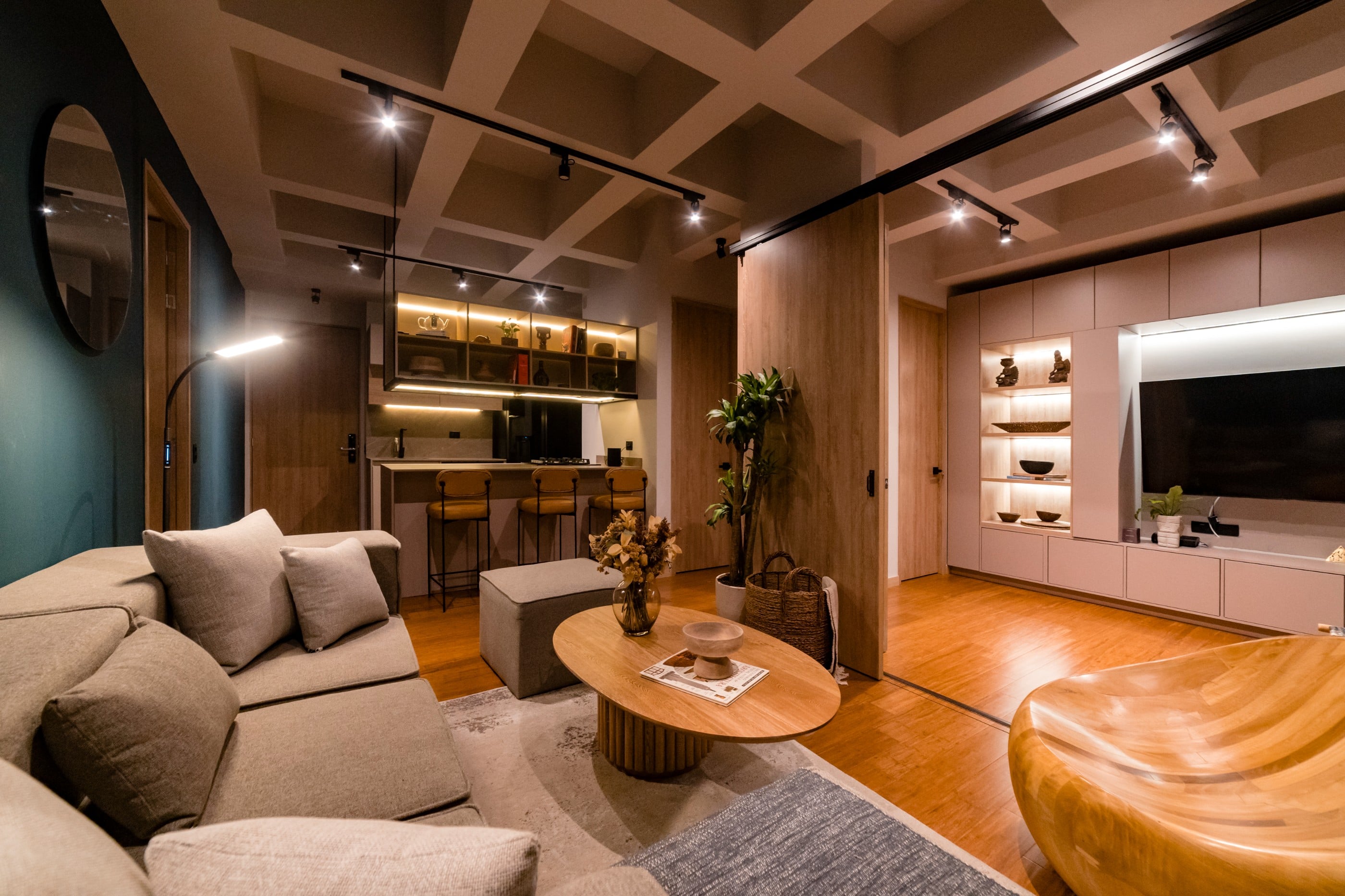 Sala del apartamento Campestre 402 con techo artesonado, madera y sofás en tonos tierra, Medellín