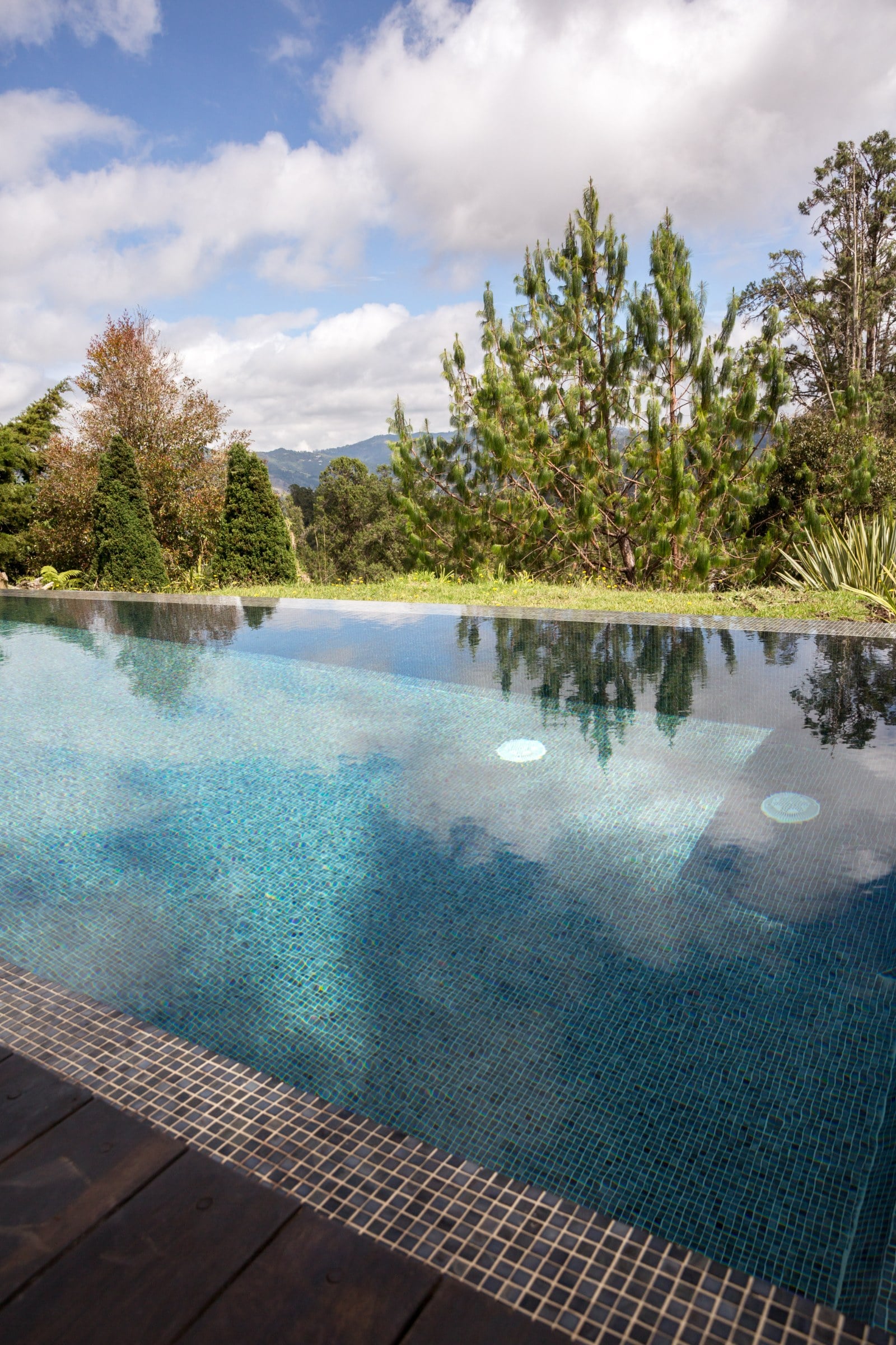 Piscina con borde en madera y bosque al fondo, Casa 64, El Retiro