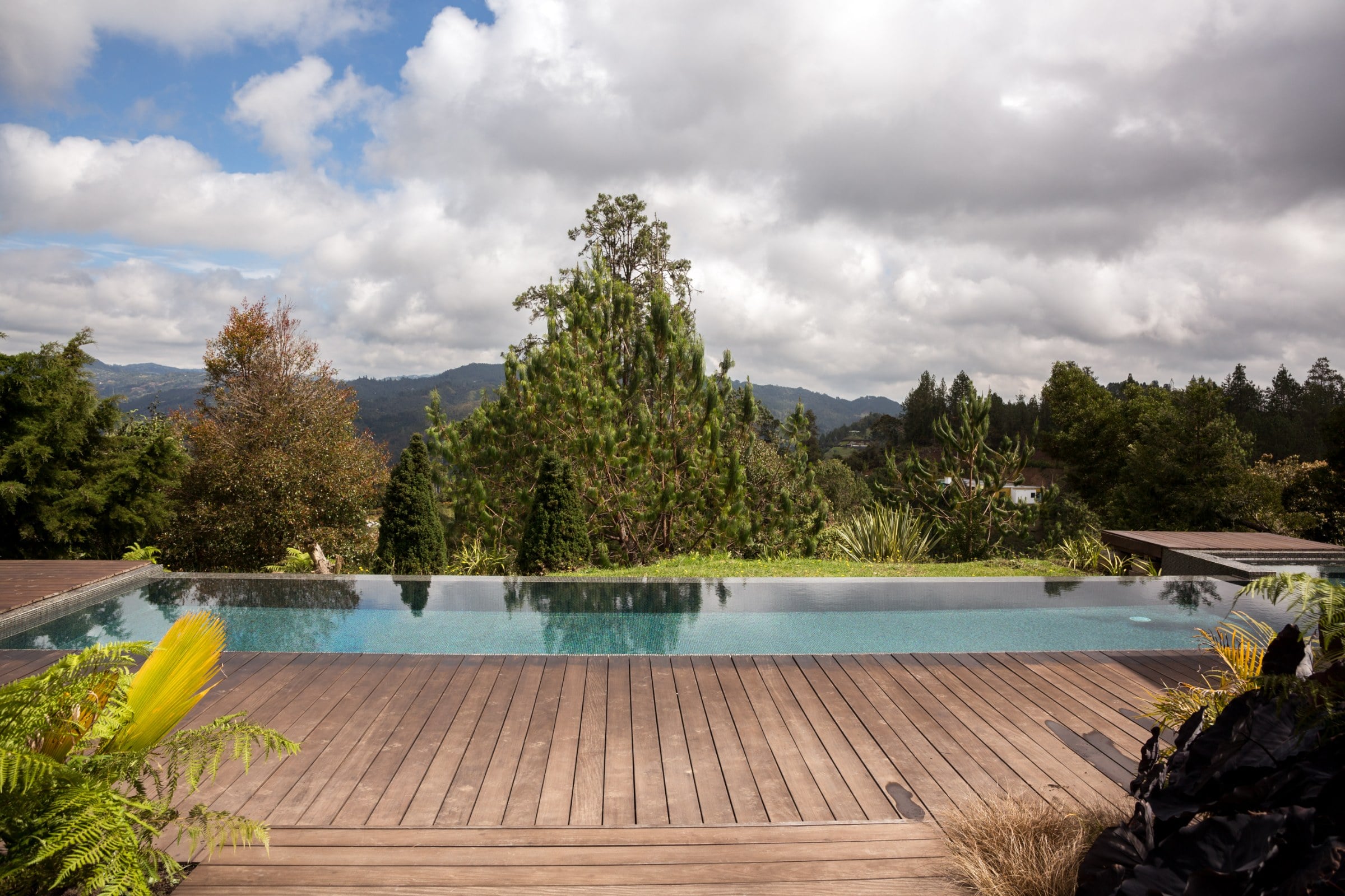 Deck en madera junto a la piscina infinita, Casa 64
