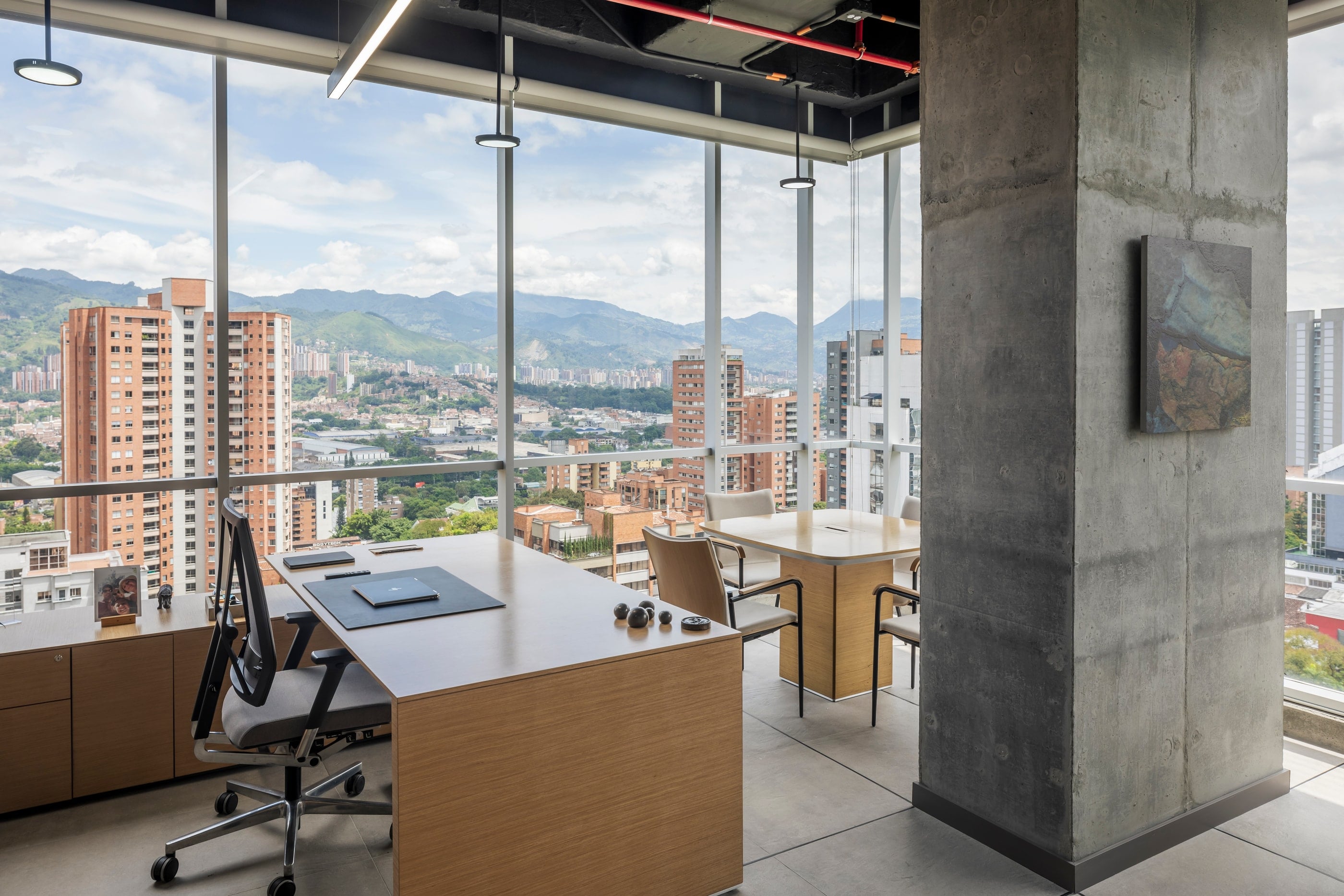 Despacho con columna de concreto a la vista y obra de arte, CrearCimientos