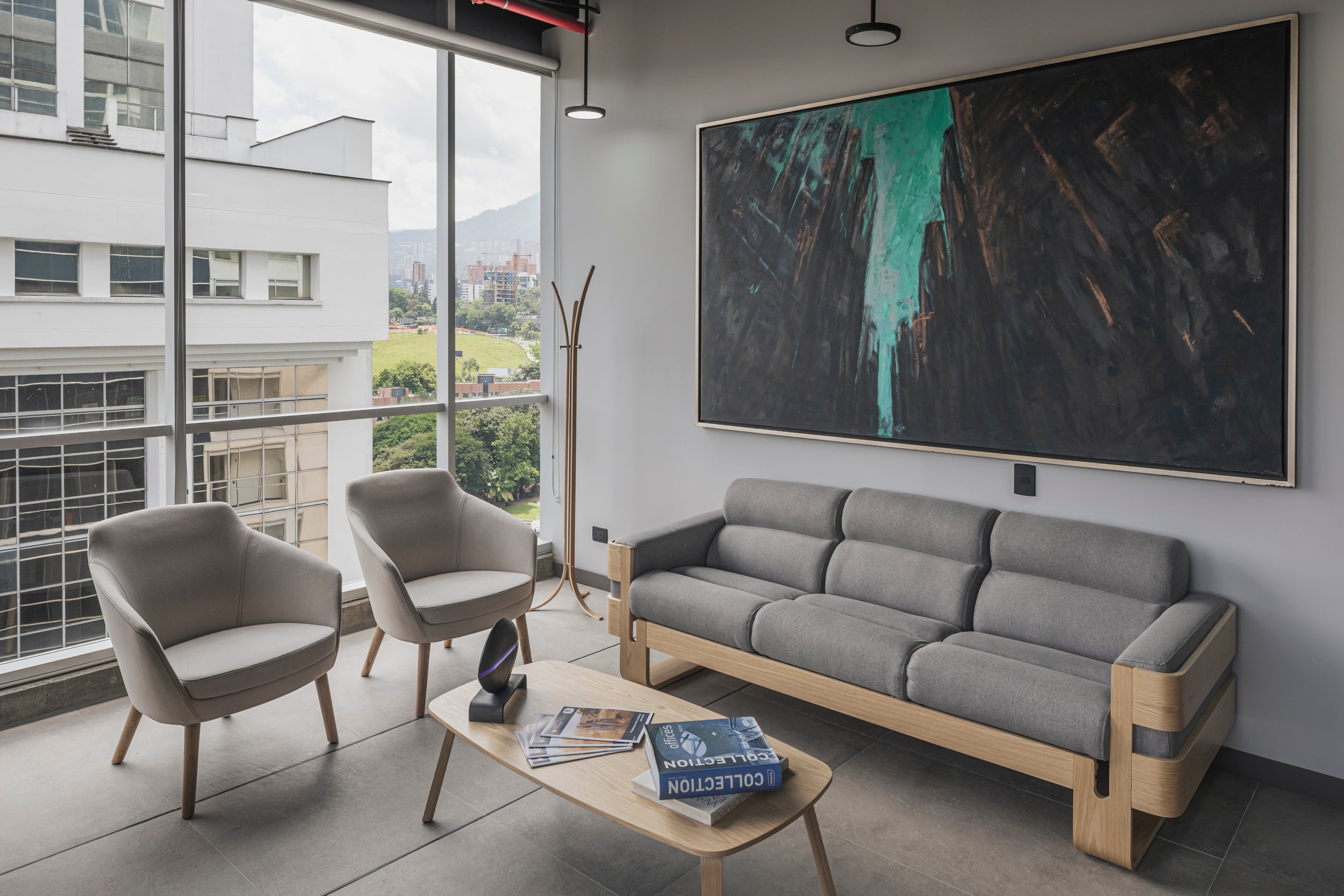 Sala de espera con sofá gris y obra de gran formato, CrearCimientos